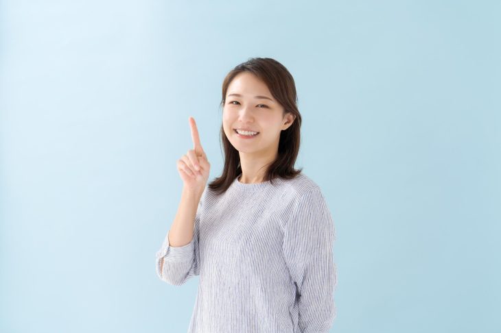 人さし指を立てる女性
