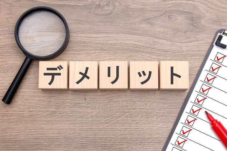 デメリットと書かれたブロックとルーペ、チェックリスト