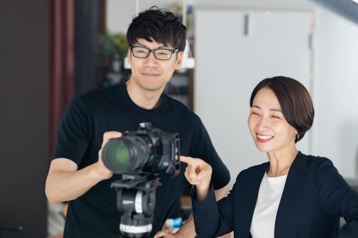 一眼レフカメラを操作しているフォトグラファー