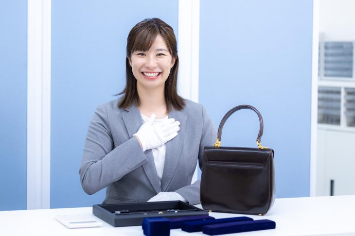 バッグや貴金属を査定する女性スタッフ