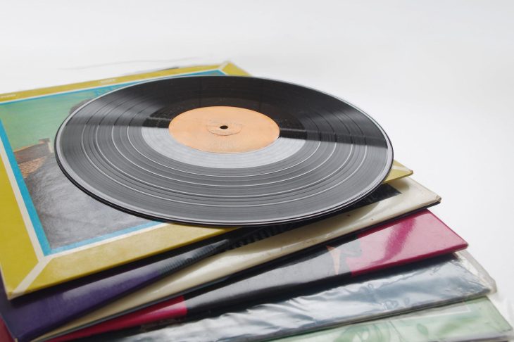 何枚も積み上げたレコードジャケットの上に置いたレコード盤