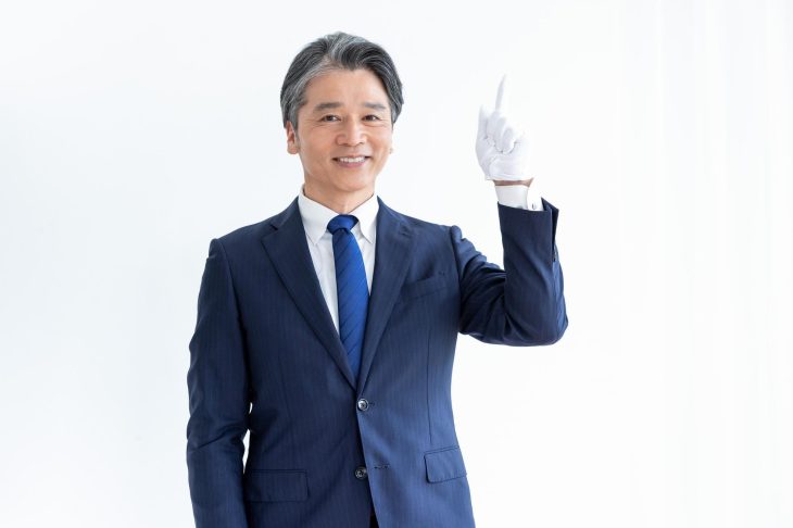 笑顔で上空を指さしている男性