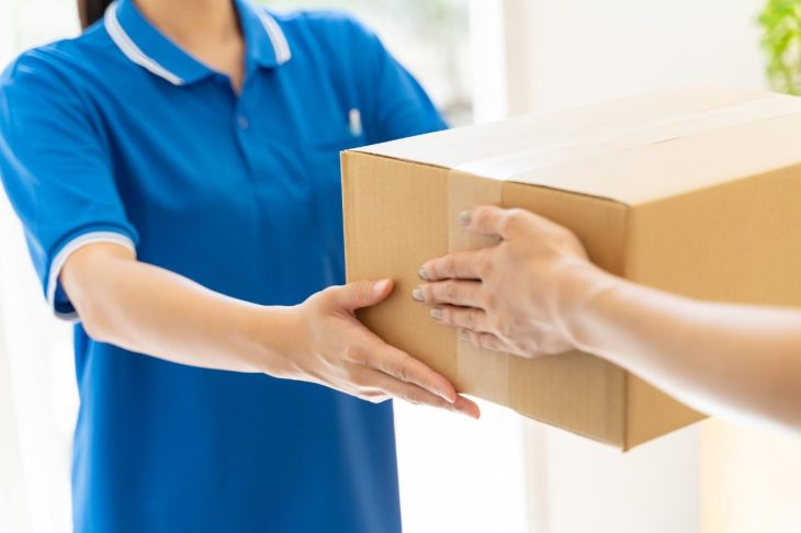 荷物を宅配業者に渡す人の手元