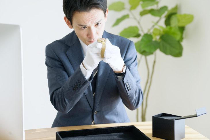 金の時計を査定する男性