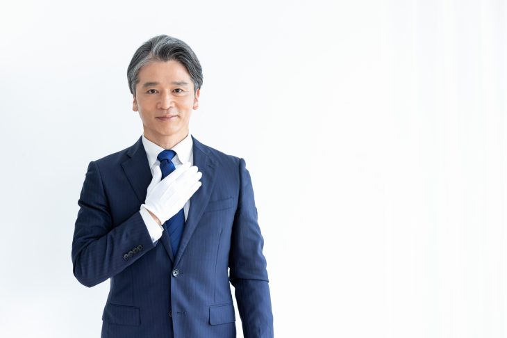 白い手袋を付けて胸を張る査定士