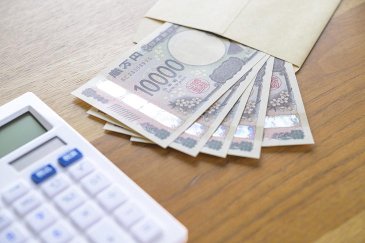 電卓と封筒の中に入った現金