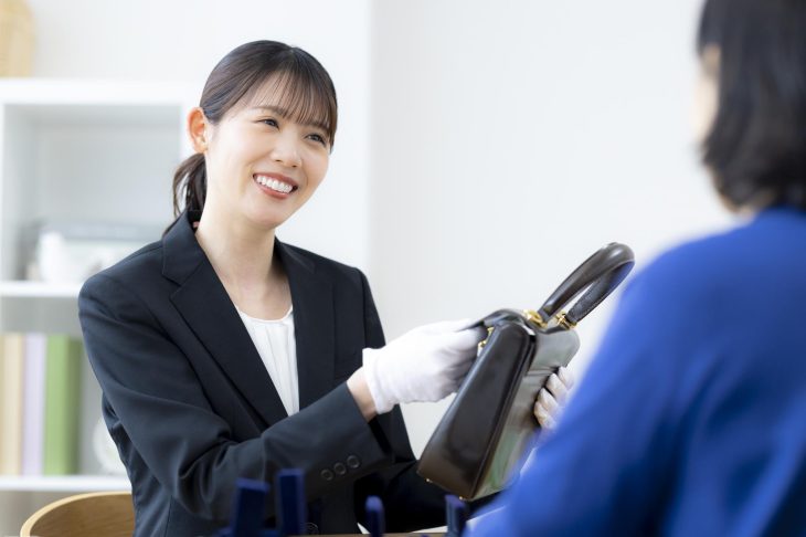 バッグを丁寧に査定している女性