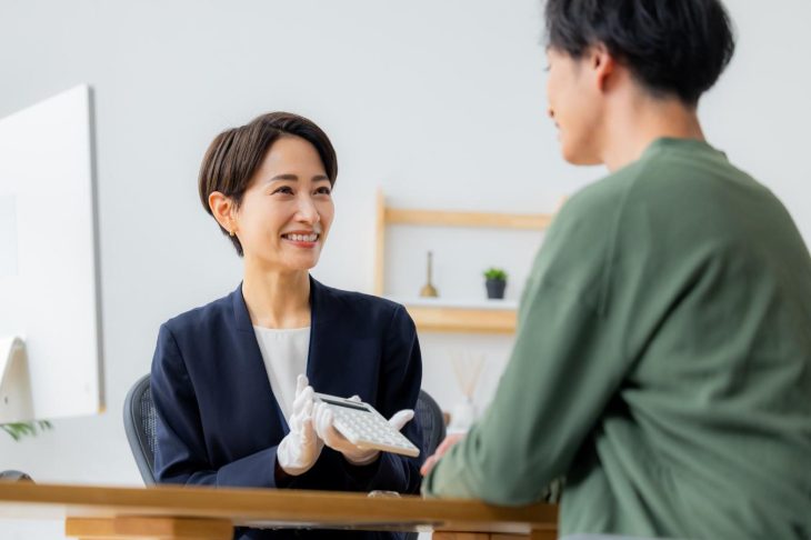 金額を提示する査定士風の女性