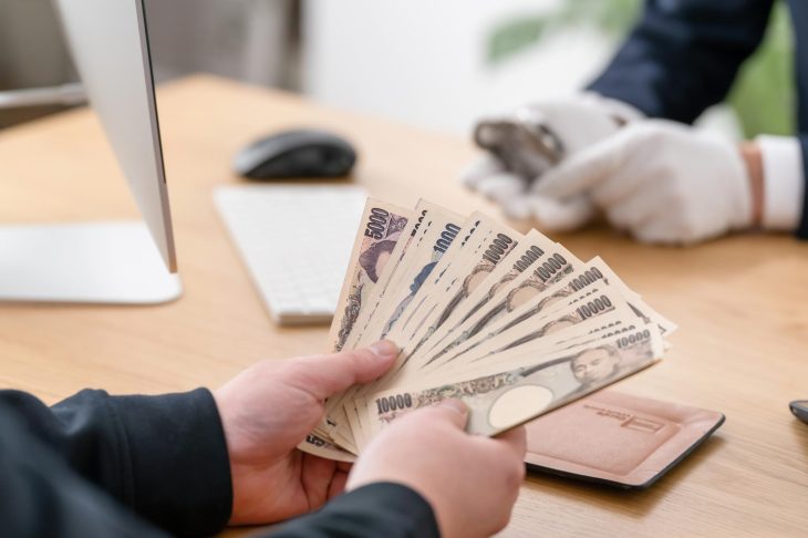 買取店でお金を受け取る男性の手元