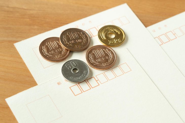はがきの上に置かれた5枚の硬貨