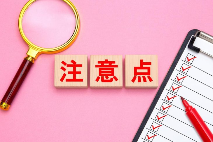注意点と書かれた木製ブロックと虫眼鏡、チェックリスト