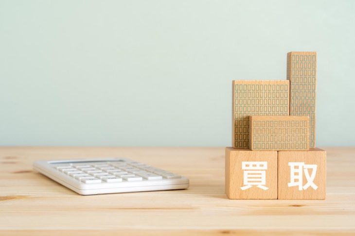 買取と書かれた木製ブロックの横に置かれた電卓
