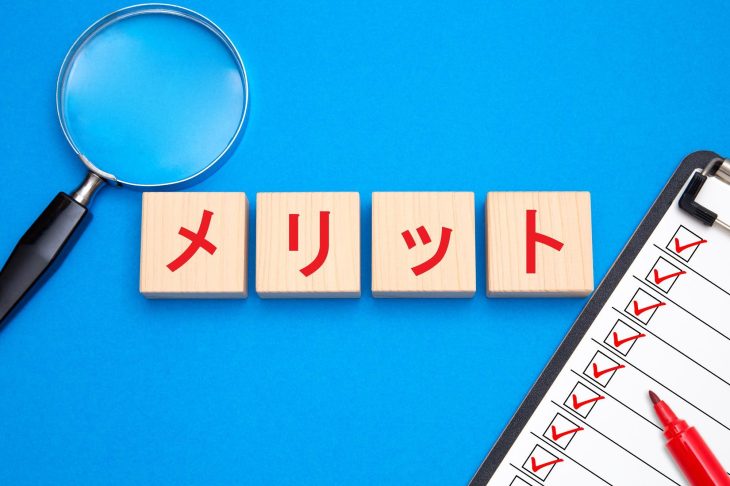 メリットと書かれたブロックとチェックリスト、ルーペ