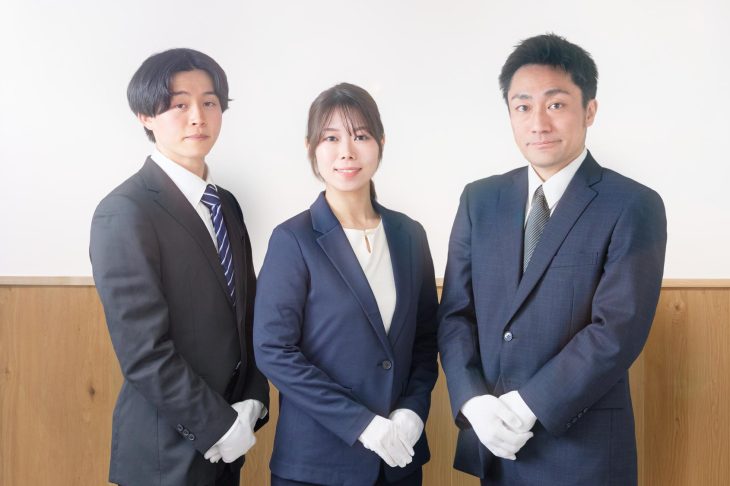 スーツを着て白い手袋をはめた3人の査定士