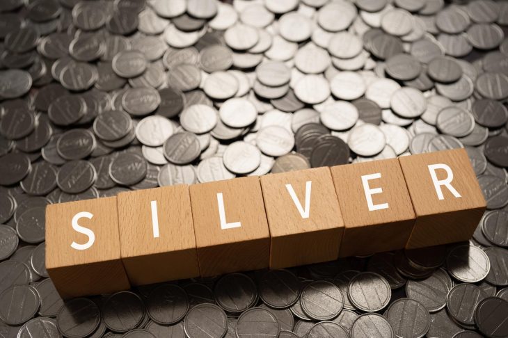 敷き詰められたコインの上に置かれた「SILVER」と書かれた木のブロック