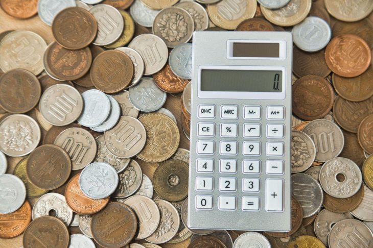 さまざまな日本の硬貨の上に置かれた電卓