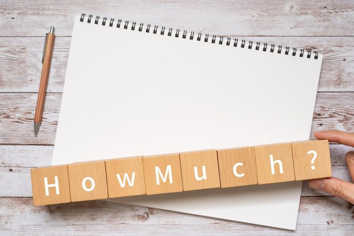 ノートの上にある「How Much?」と書かれたブロック