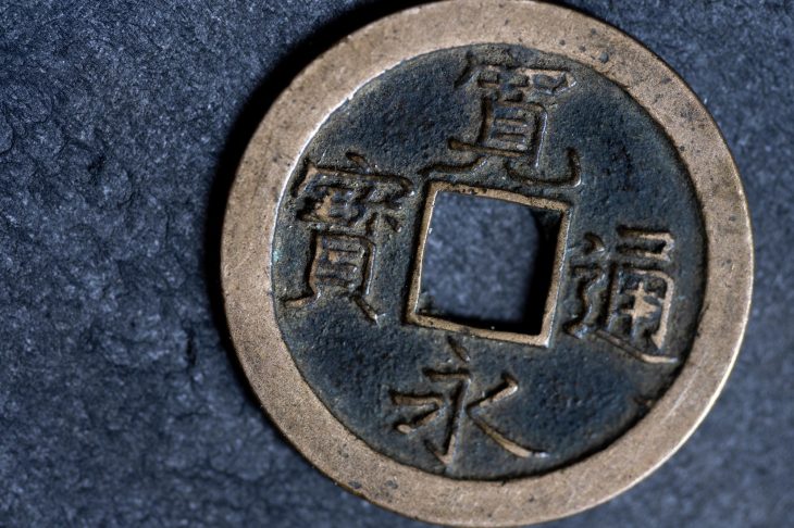黒い背景の前に置かれた寛永通宝