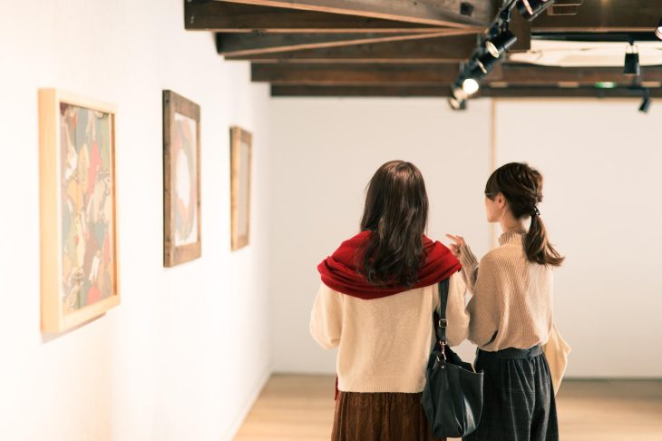 美術館に展示された絵画を見つめる女性二人組