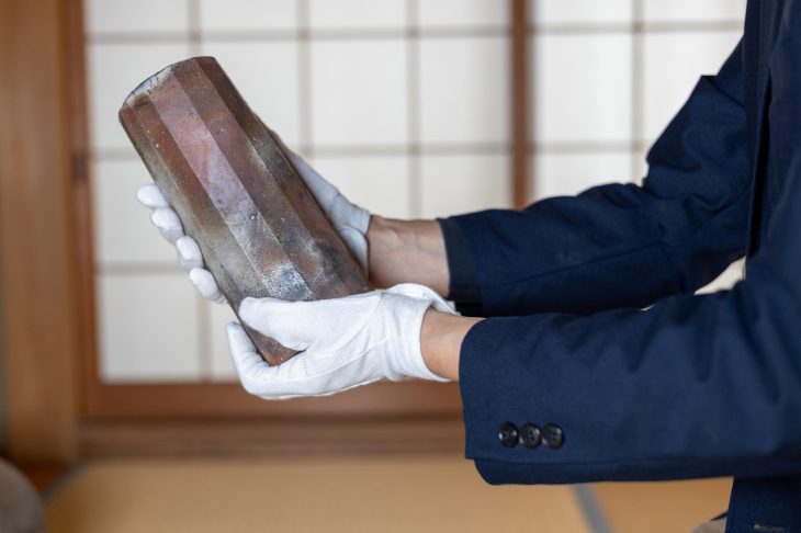骨董品を丁寧にチェックしている人の手元