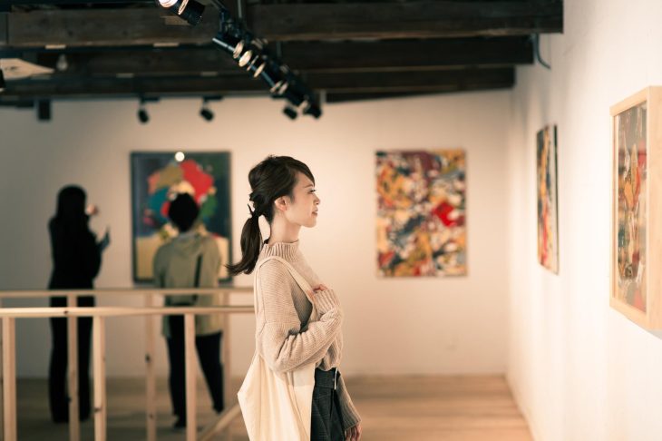 美術館に展示されている絵画を鑑賞している人々